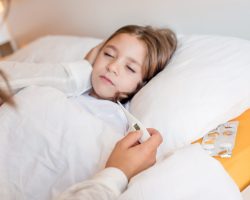 Mother taking care of her sick daughter in bedroom